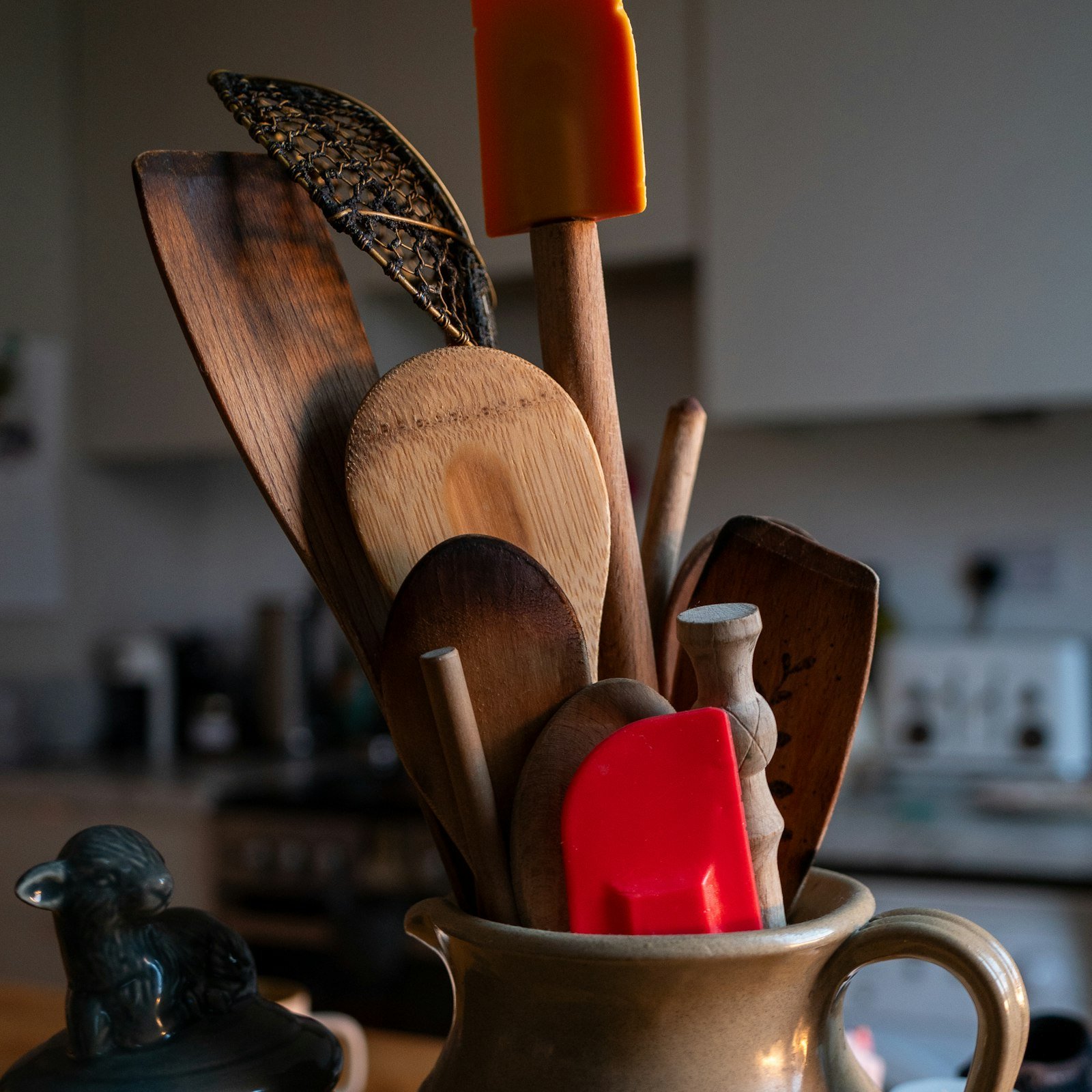 Wooden utensils in a cup on a kitchen counter