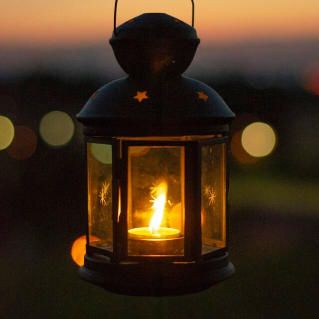Camping lantern glowing at dusk