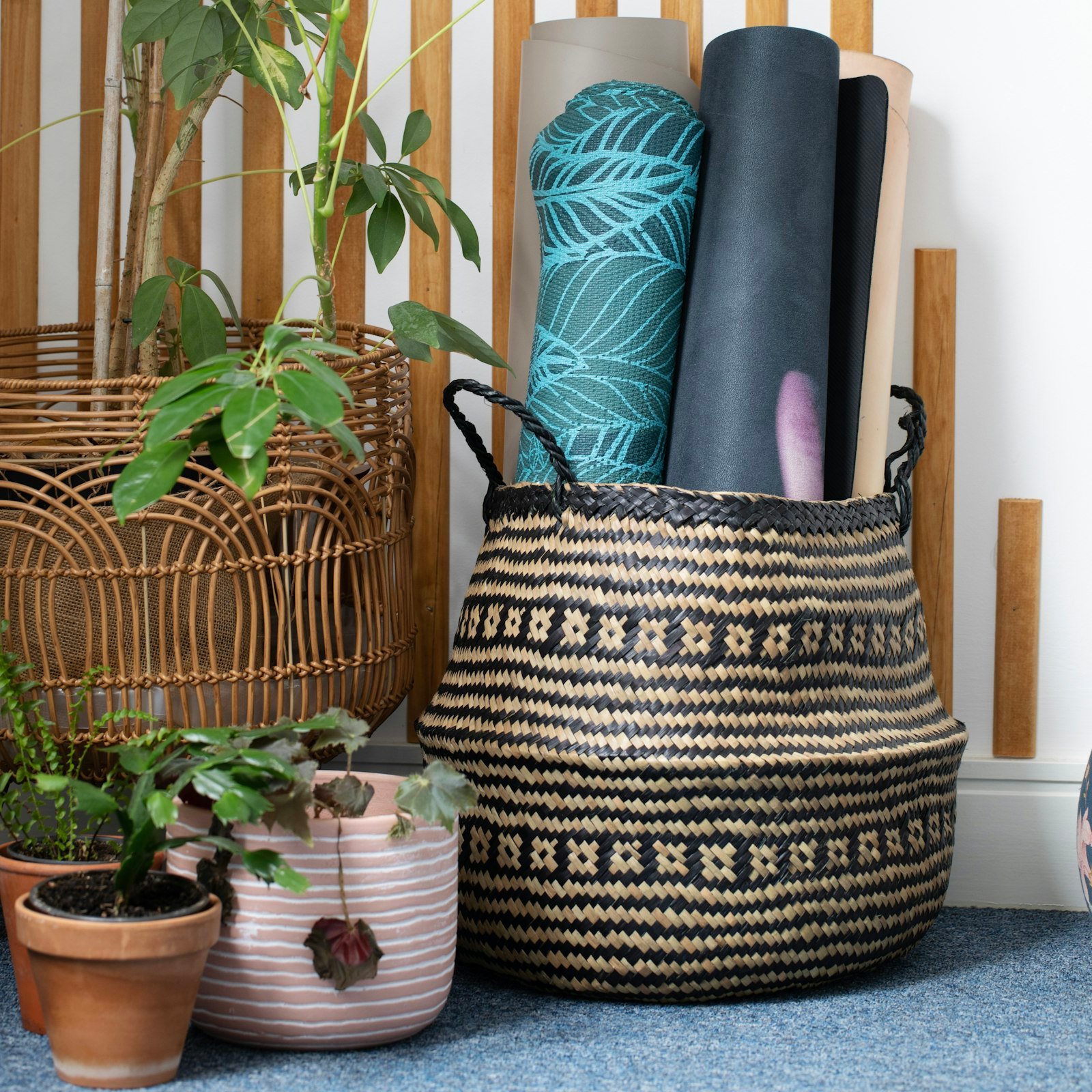 Rolled yoga mats in a woven basket